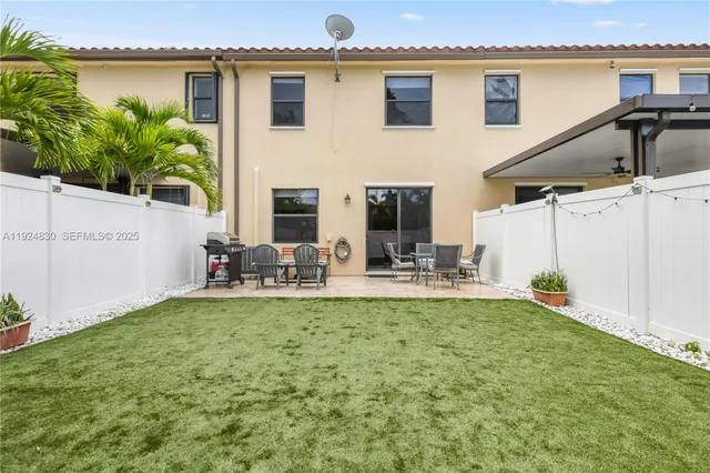 a view of a house with backyard and sitting area