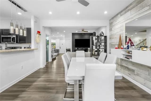 a living room with stainless steel appliances furniture and a flat screen tv