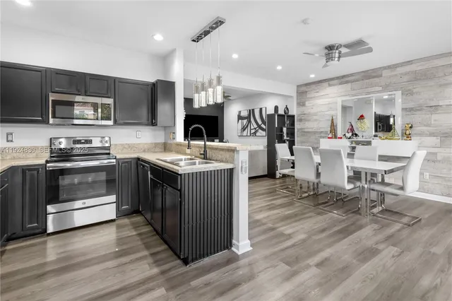 a kitchen with a sink stove cabinets and wooden floor