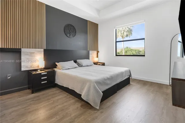 a bedroom with a bed and painting on the wall