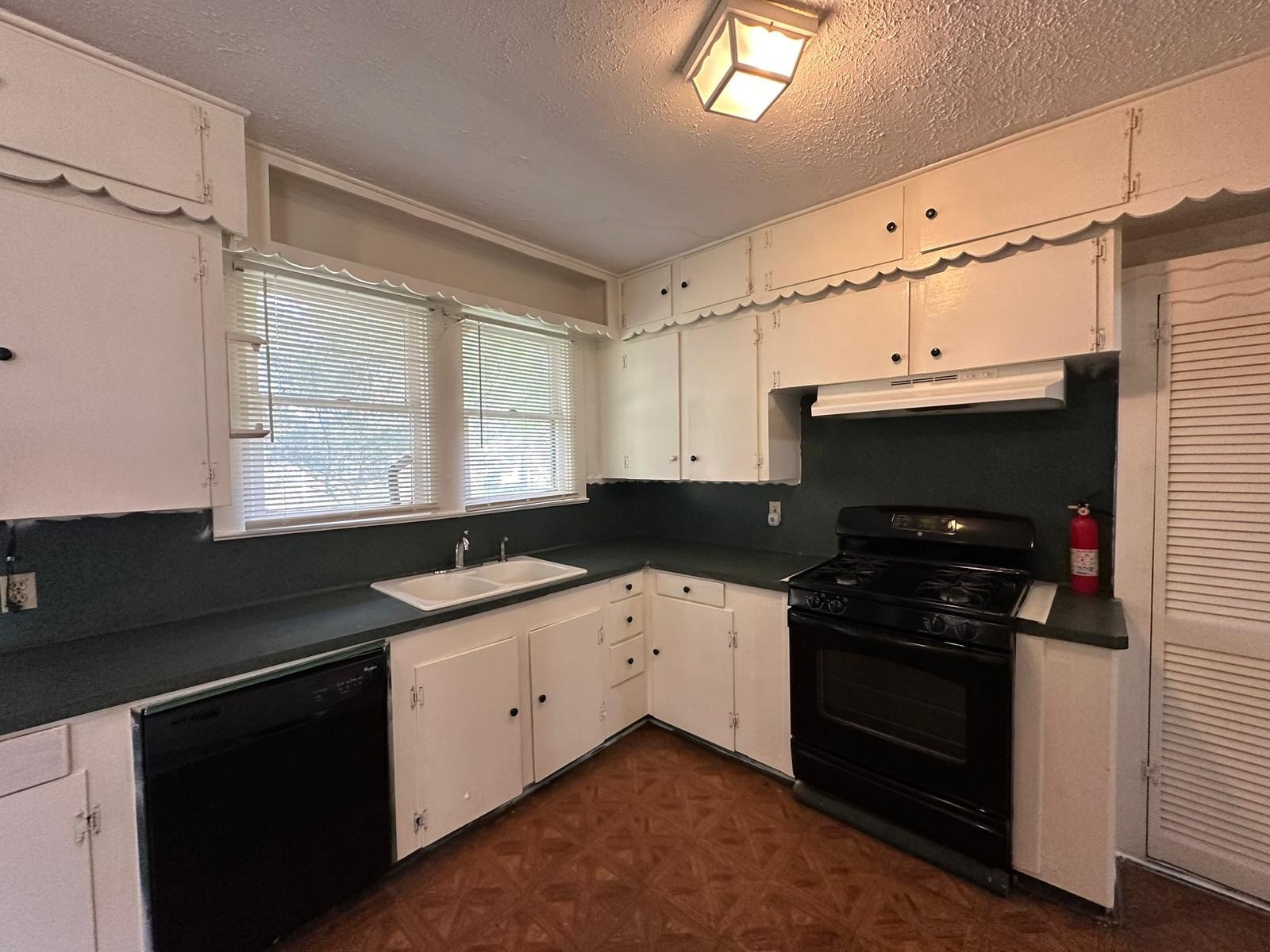 6818 Stearns Street Houston, TX 77021 - Photo 3 of 18 a kitchen with granite countertop a sink stove and cabinets