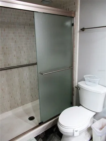 a white toilet sitting next to a shower