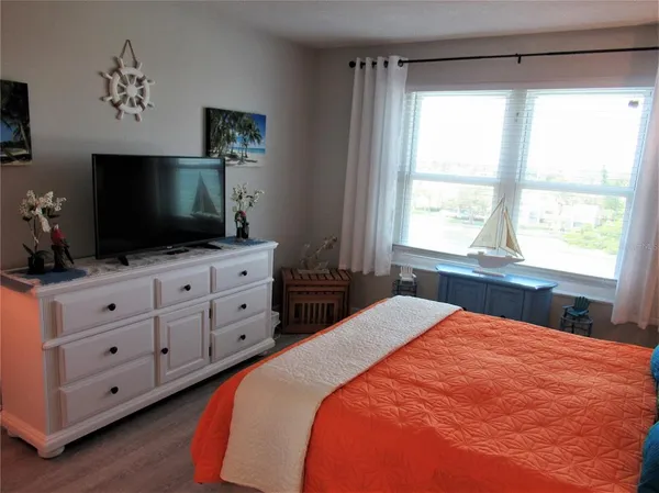 a bedroom with a bed and a flat screen tv