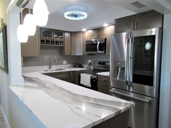 a kitchen with stainless steel appliances granite countertop a sink a stove and a refrigerator