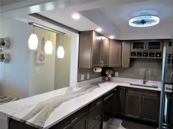 a bathroom with a granite countertop sink a light fixture and a mirror