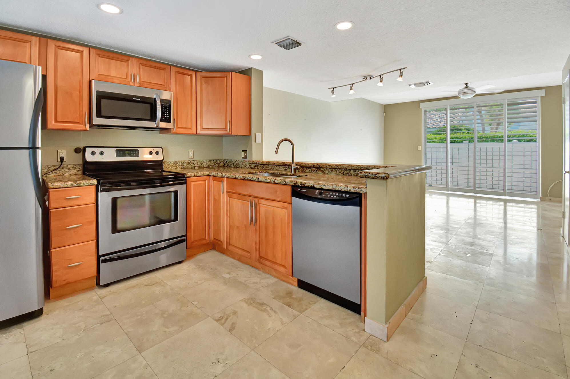 a kitchen with stainless steel appliances granite countertop a stove top oven a sink and a microwave