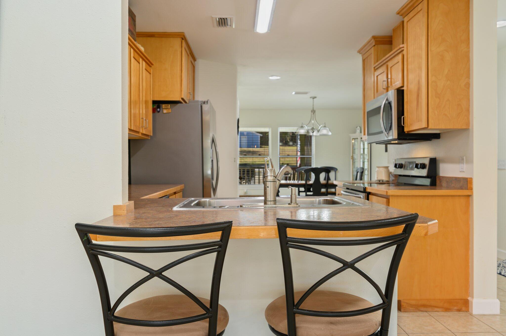 883 Squirrel Road DeFuniak Springs, FL 32433 - Photo 15 of 57 a kitchen with stainless steel appliances granite countertop a table chairs sink and cabinets