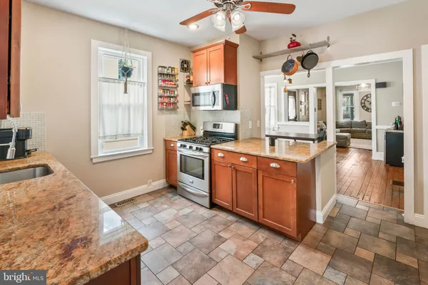 a kitchen with stainless steel appliances granite countertop a stove a sink and a refrigerator