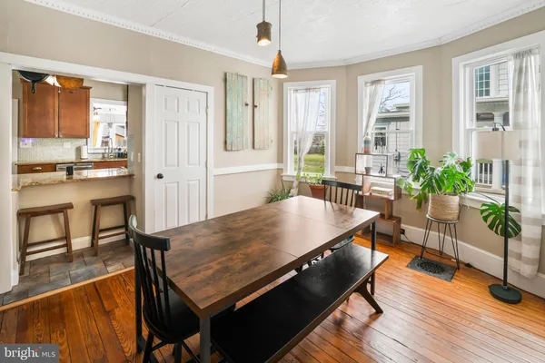 a living room with furniture a large window wooden floor and front door