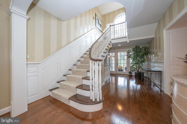 a kitchen with stainless steel appliances kitchen island granite countertop dining table chairs and a refrigerator