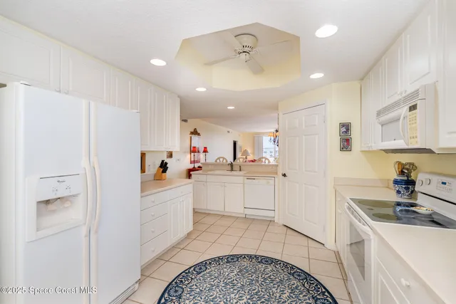 a kitchen with white cabinets and white appliances