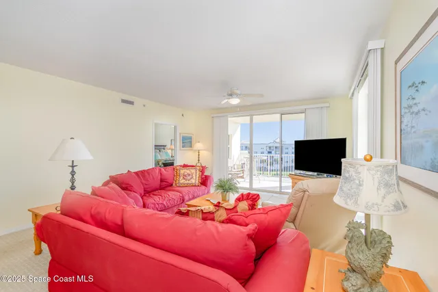 a living room with furniture a flat screen tv and a window