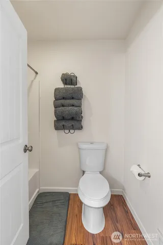 a white toilet sitting next to a shower