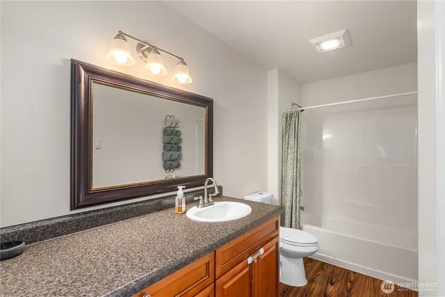 a bathroom with a granite countertop sink toilet and shower