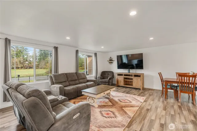 a living room with furniture a flat screen tv and a large window