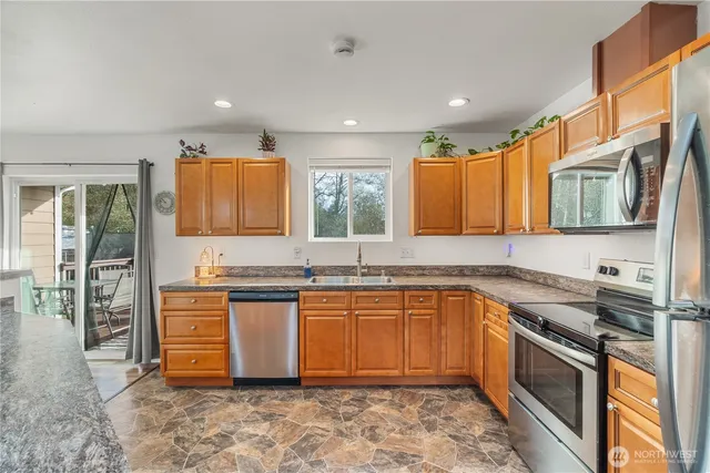 a kitchen with stainless steel appliances granite countertop a sink stove and refrigerator
