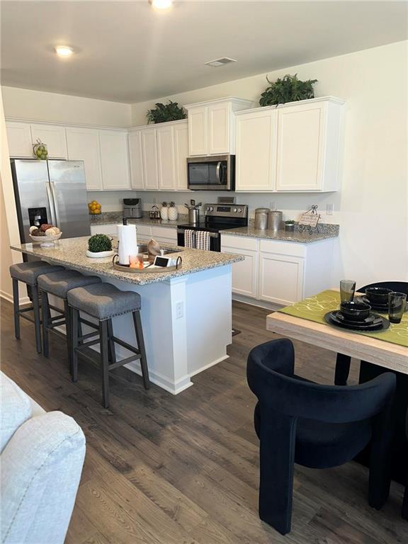 103 Hampton Street McDonough, GA 30253 - Photo 7 of 17 a kitchen with stainless steel appliances granite countertop a table chairs sink and cabinets