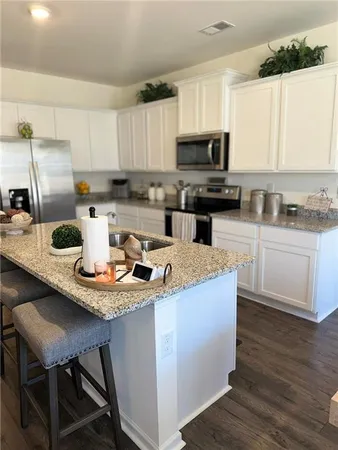 a kitchen with kitchen island white cabinets and stainless steel appliances