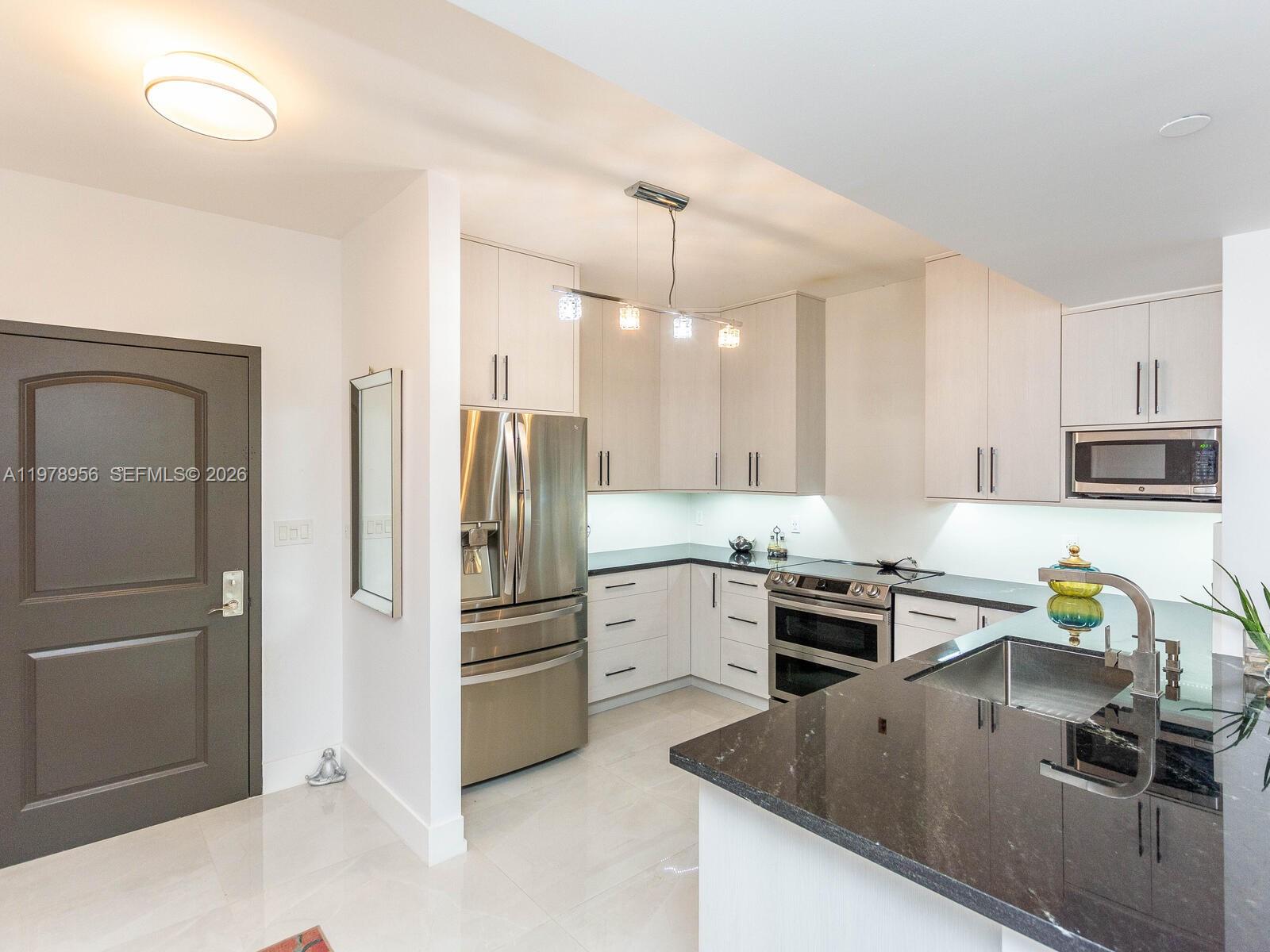 7350 Southwest 89th Street, Unit 719S Miami, FL 33156 - Photo 12 of 30 a kitchen with kitchen island a counter top space stainless steel appliances and cabinets