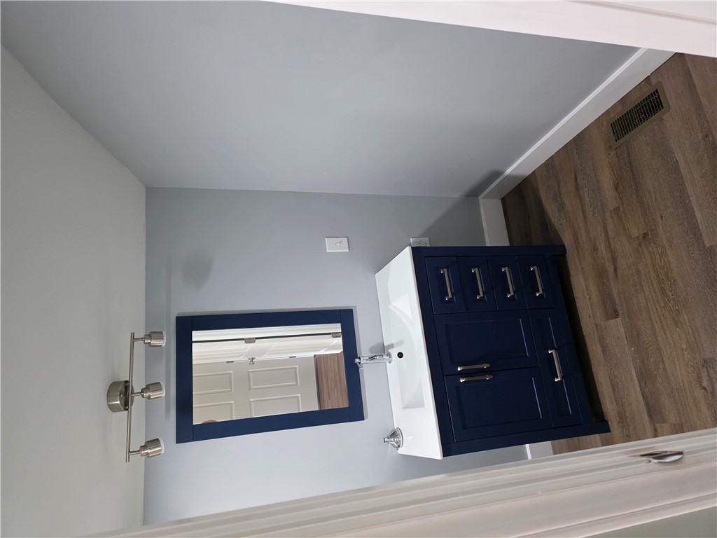 112 Simmons Street Anderson, SC 29625 - Photo 13 of 26 A refined bathroom vanity featuring a deep blue cabinet and sleek hardware.