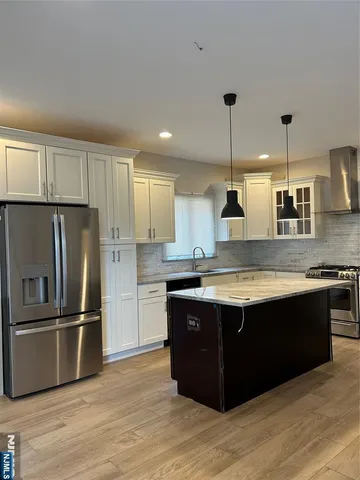 a large kitchen with granite countertop a sink and stainless steel appliances