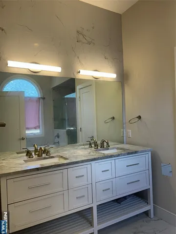 a bathroom with a double vanity sink and a mirror