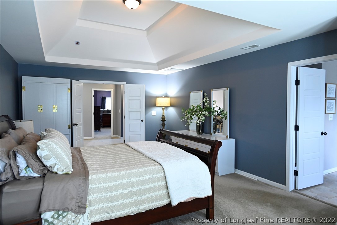 43 Lancaster Court Spring Lake, NC 28390 - Photo 23 of 44 a bedroom with a bed and a potted plant