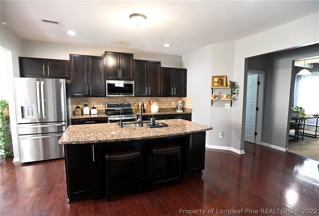 43 Lancaster Court Spring Lake, NC 28390 - Photo 8 of 44 a kitchen with stainless steel appliances granite countertop a stove a refrigerator and a view of kitchen island