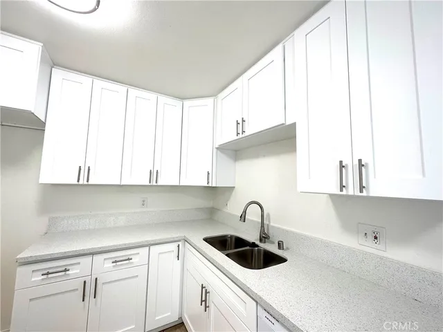 a kitchen with a sink a window and cabinets