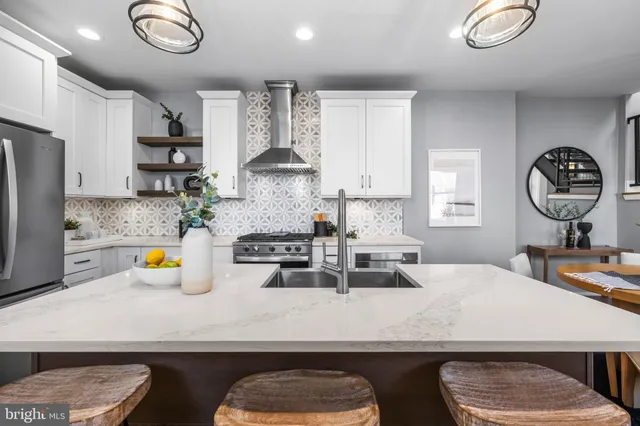 a view of a dining room with furniture a kitchen and chandelier