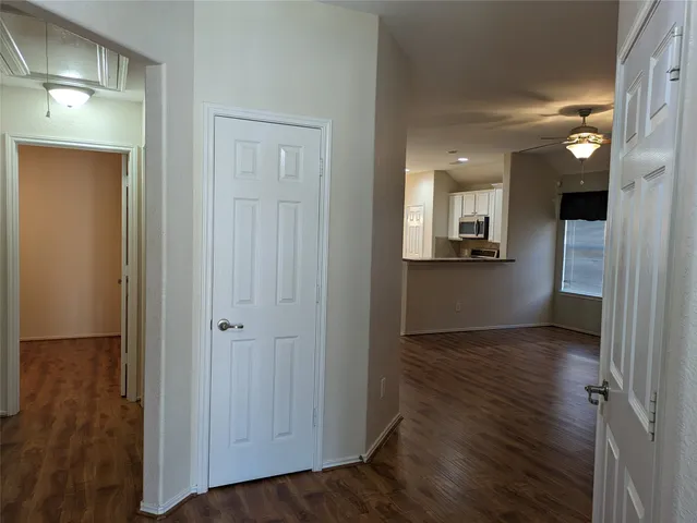 an empty room with wooden floor and a bathroom