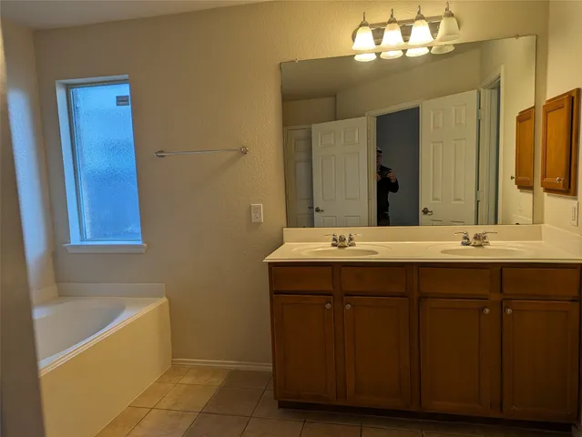 a bathroom with a tub sink and mirror