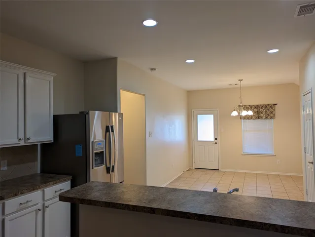 a bathroom with a sink a large mirror and a refrigerator