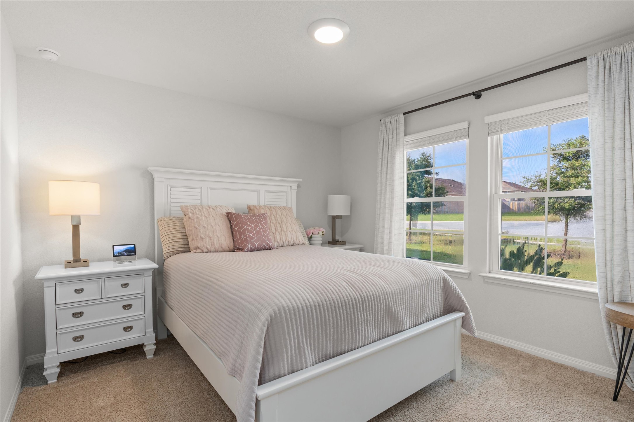 19912 Abigail Fillmore Road Manor, TX 78653 - Photo 14 of 31 Natural light streams into this serene bedroom, highlighting plush carpet and a well-appointed headboard.