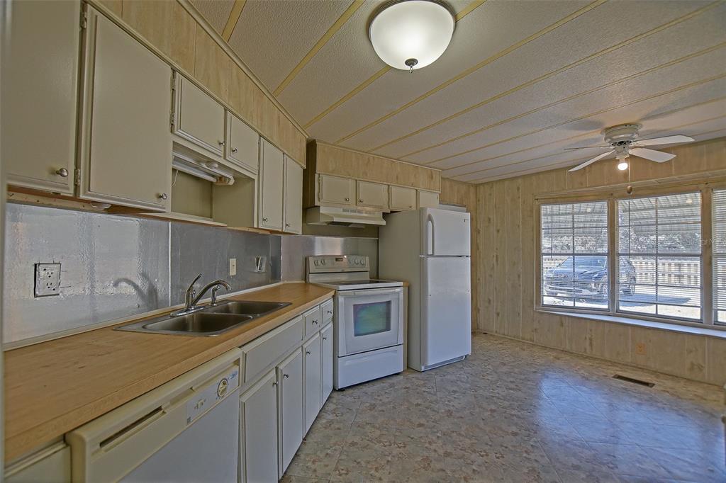 7452 Southeast 135th Street Summerfield, FL 34491 - Photo 26 of 43 a kitchen that has a sink cabinets counter space and appliances