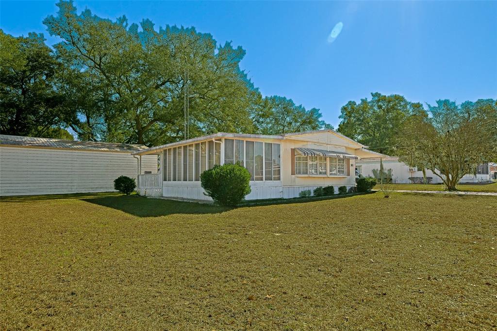 7452 Southeast 135th Street Summerfield, FL 34491 - Photo 3 of 43 a front view of house with yard and trees in the background