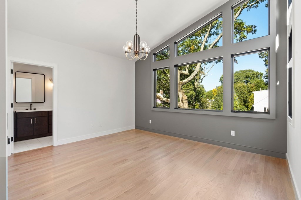140 Roundwood Road Newton, MA 02464 - Photo 25 of 40 a view of an empty room with a window and wooden floor