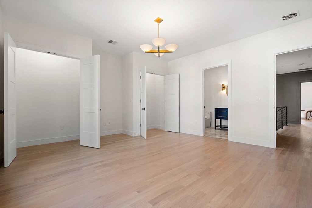 140 Roundwood Road Newton, MA 02464 - Photo 29 of 40 a view of an empty room with wooden floor and a window