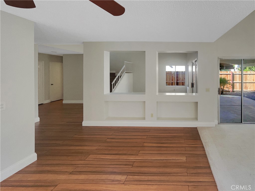 662 Spinnaker Drive Perris, CA 92571 - Photo 11 of 23 a view of a hallway with wooden floor and a living room
