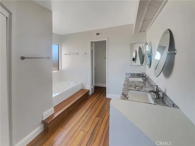a bathroom with a granite countertop double vanity sink and a mirror