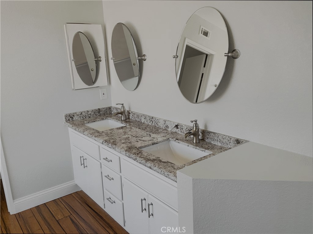 662 Spinnaker Drive Perris, CA 92571 - Photo 19 of 23 a bathroom with a granite countertop double vanity sink and a mirror