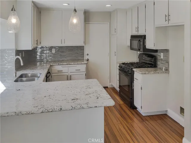 a kitchen with granite countertop a sink stove and refrigerator