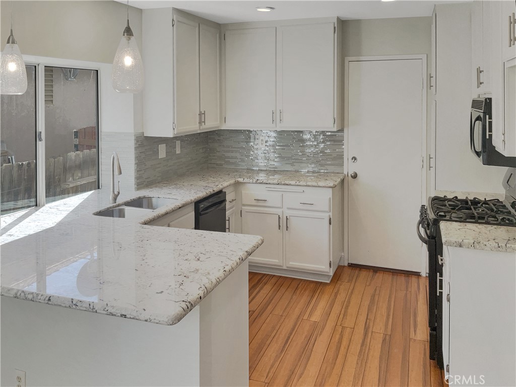 662 Spinnaker Drive Perris, CA 92571 - Photo 10 of 23 a kitchen with granite countertop a sink a stove and refrigerator