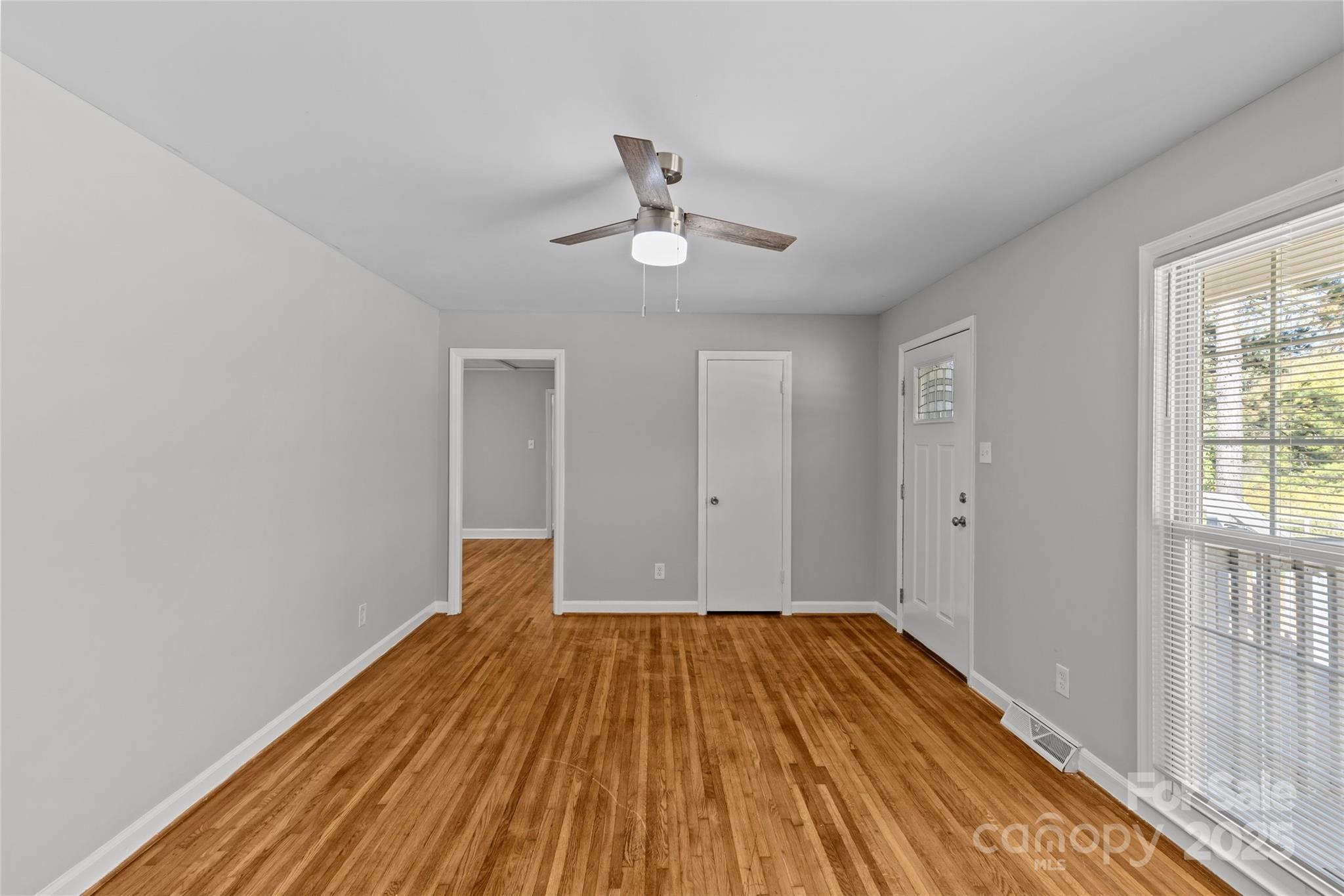 8341 Reedy Creek Road Charlotte, NC 28215 - Photo 11 of 40 a view of a room with wooden floor ceiling fan and windows