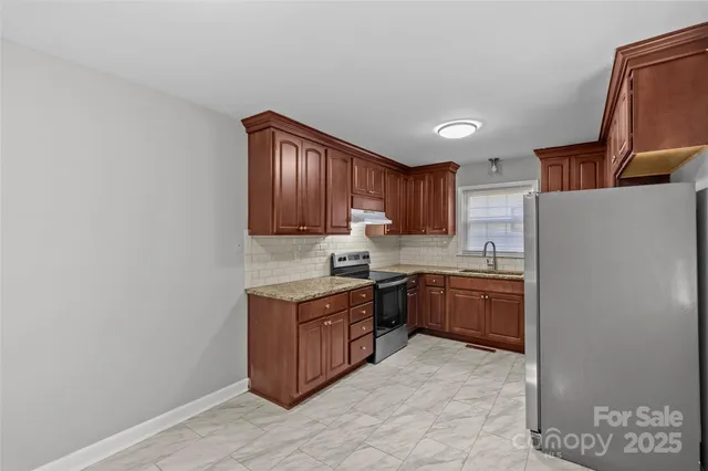 a kitchen with stainless steel appliances granite countertop a stove sink and cabinets