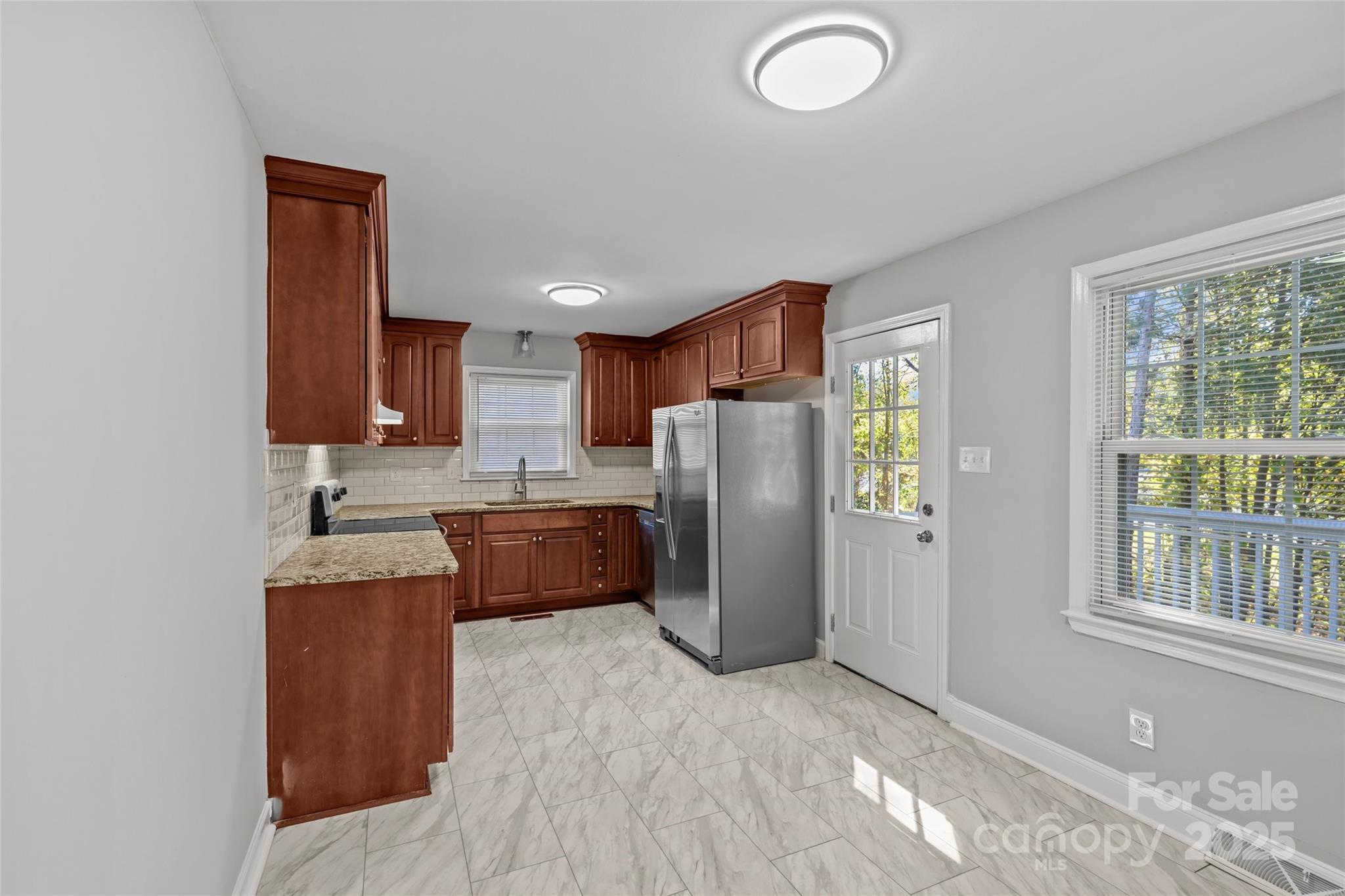 8341 Reedy Creek Road Charlotte, NC 28215 - Photo 19 of 40 a kitchen with stainless steel appliances granite countertop a refrigerator sink and wooden cabinets