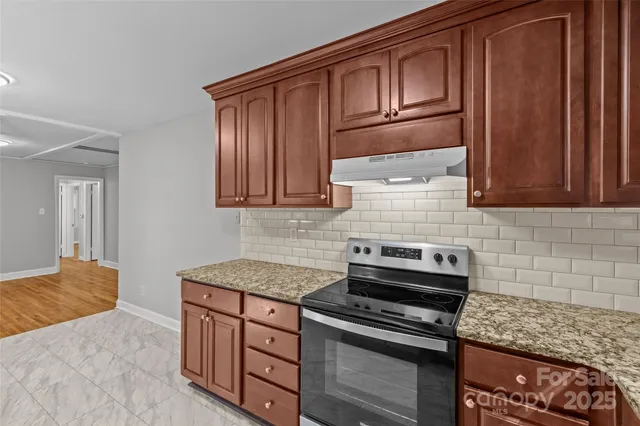 a kitchen with wooden cabinets and a stove top oven