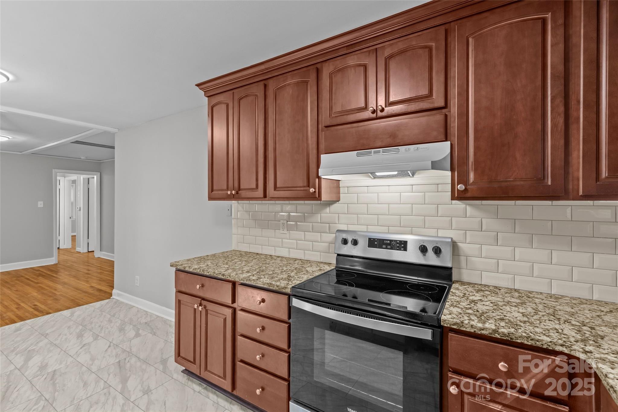 8341 Reedy Creek Road Charlotte, NC 28215 - Photo 27 of 40 a kitchen with wooden cabinets and a stove top oven