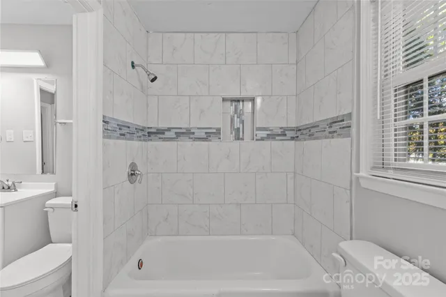 a bath tub sitting next to a white sink and vanity