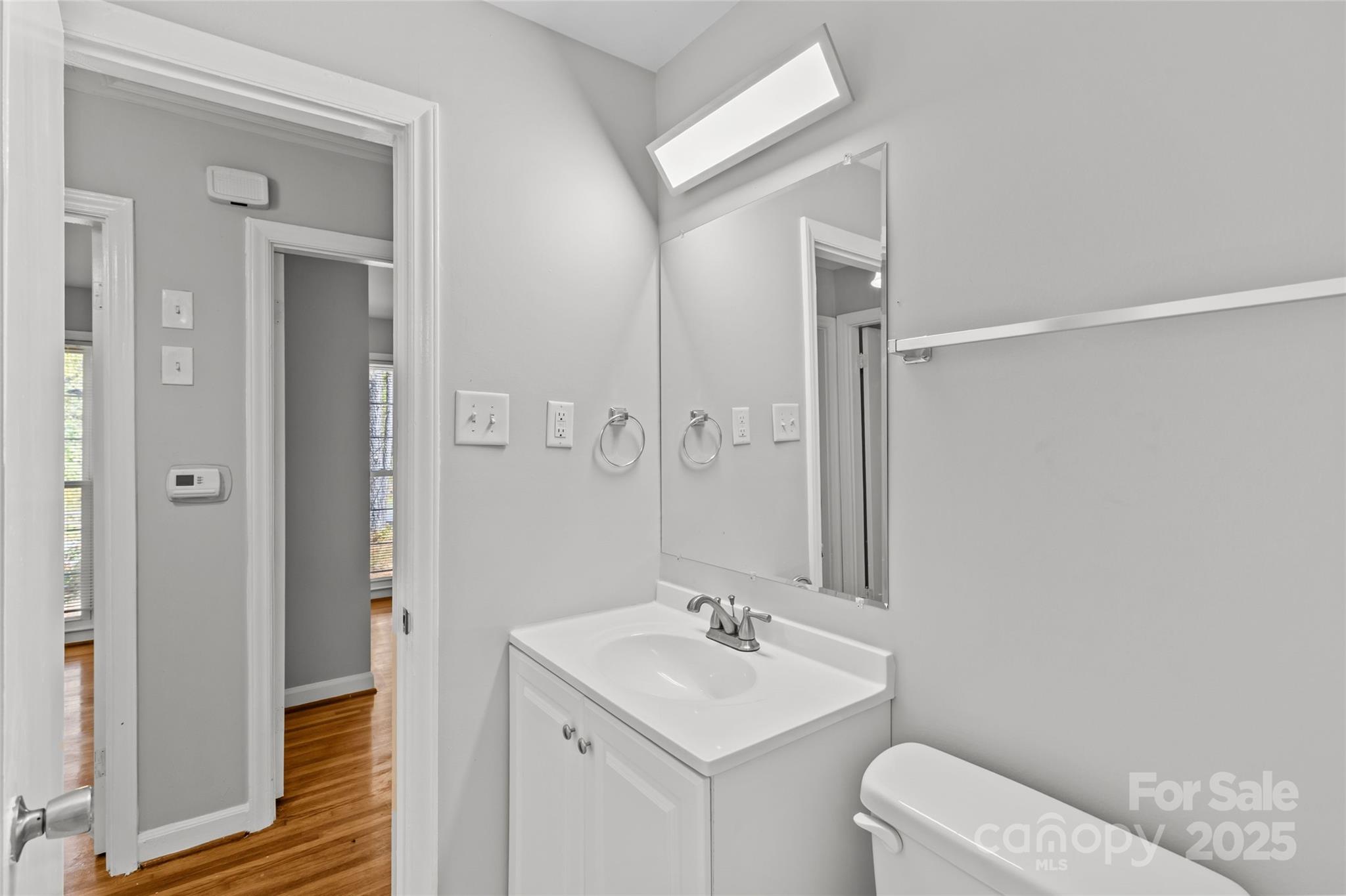 8341 Reedy Creek Road Charlotte, NC 28215 - Photo 32 of 40 a bathroom with a toilet a sink a mirror and vanity